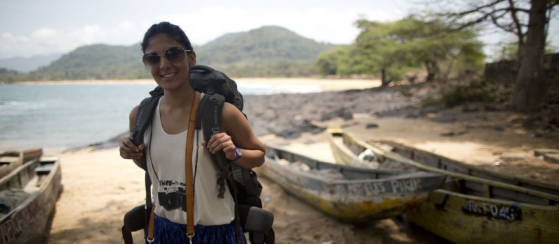 A smiling woman backpacker on a beach 
