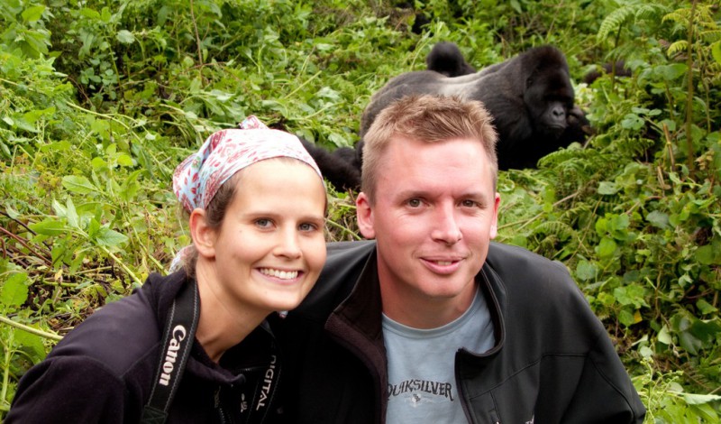 Couple smiling in front a gorillas in the wild