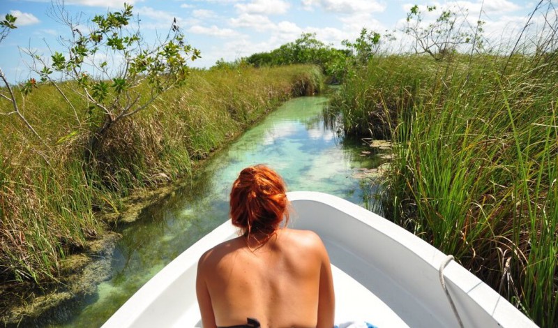A woman sunbathing on a boat in Tulum