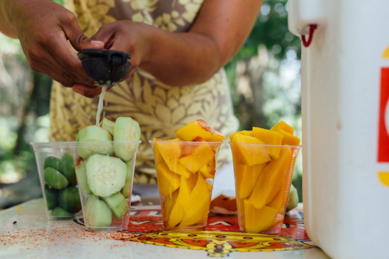A woman putting lime of fresh fruits and vegetables