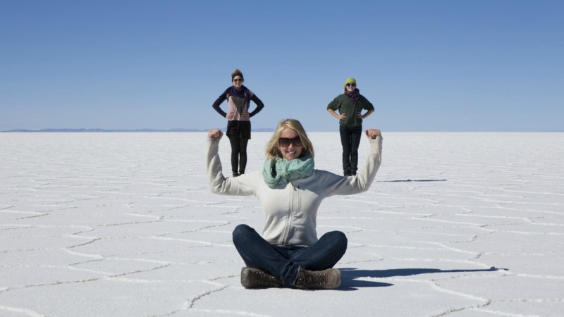 Three woman taken optical illusion photos on the Uyuni Salt Flats