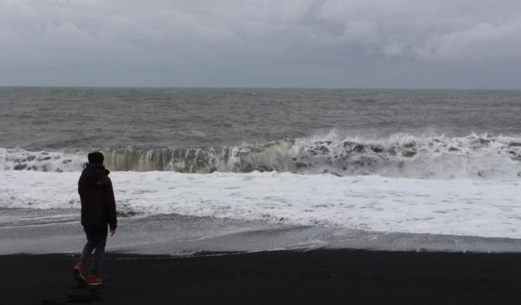 Watching the tide roll in at Black Sand Beach- 2 Weeks in Iceland 