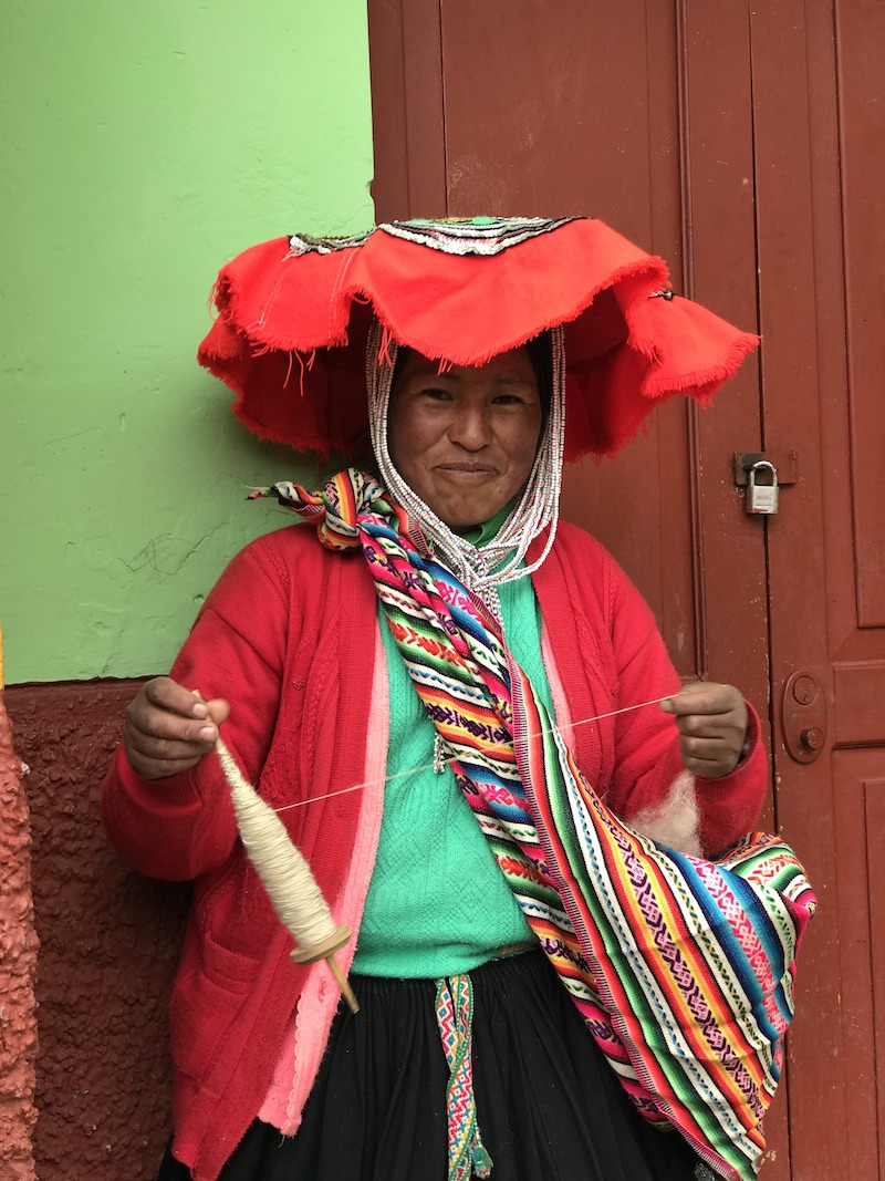 A brightly dressed Peruvian woman smiling at the camera