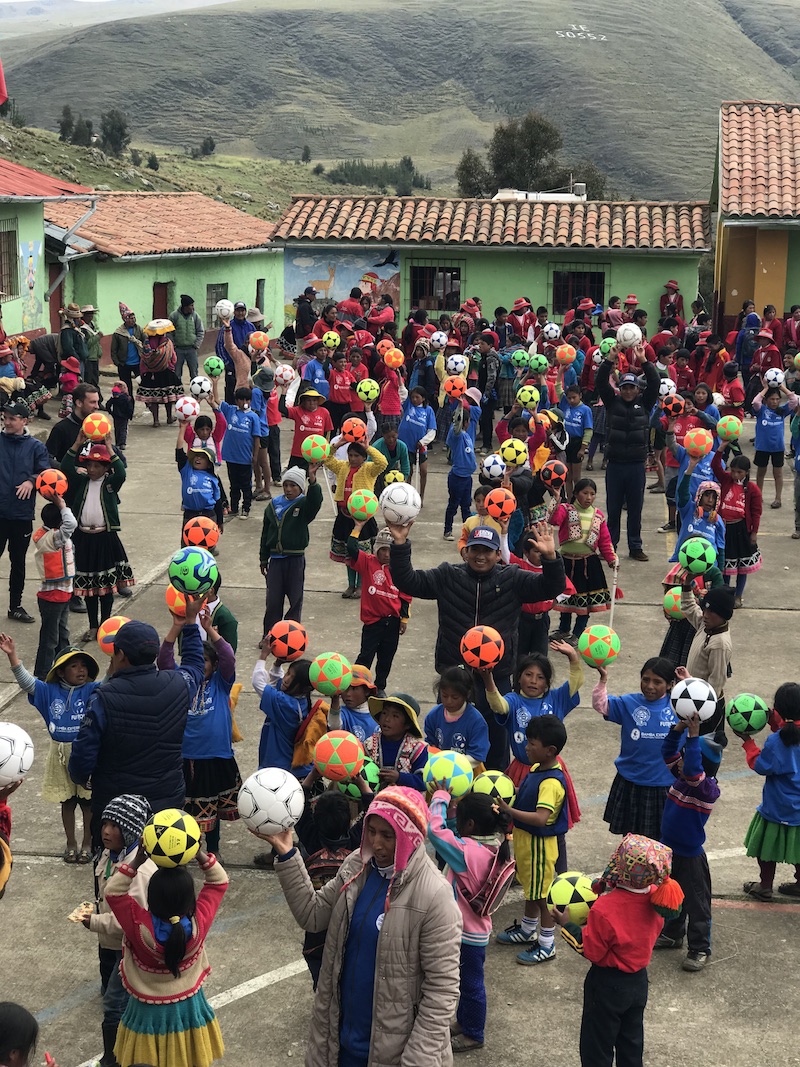 A large group a peruvian children with footballs given to them by Futbol for Kids