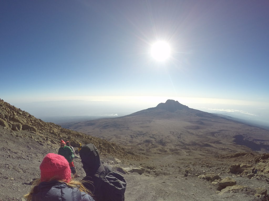 Small group hiking in the direction of the sun on Mount Kilimanjaro