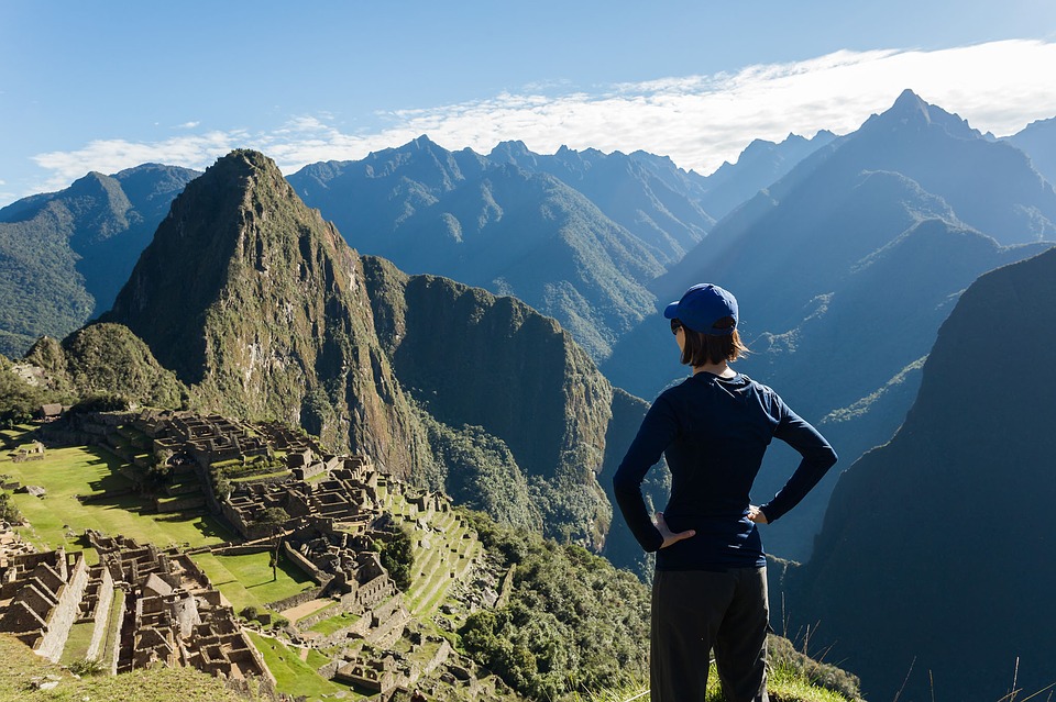 Woman in cap looks out of Machu Pichu