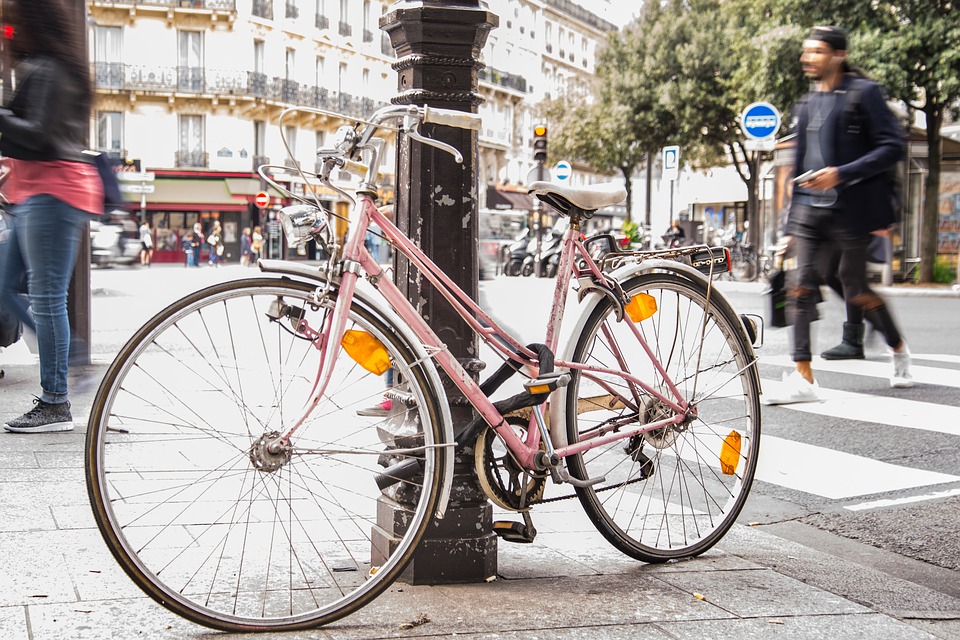 Bike leaning against a pole in a street in Paris