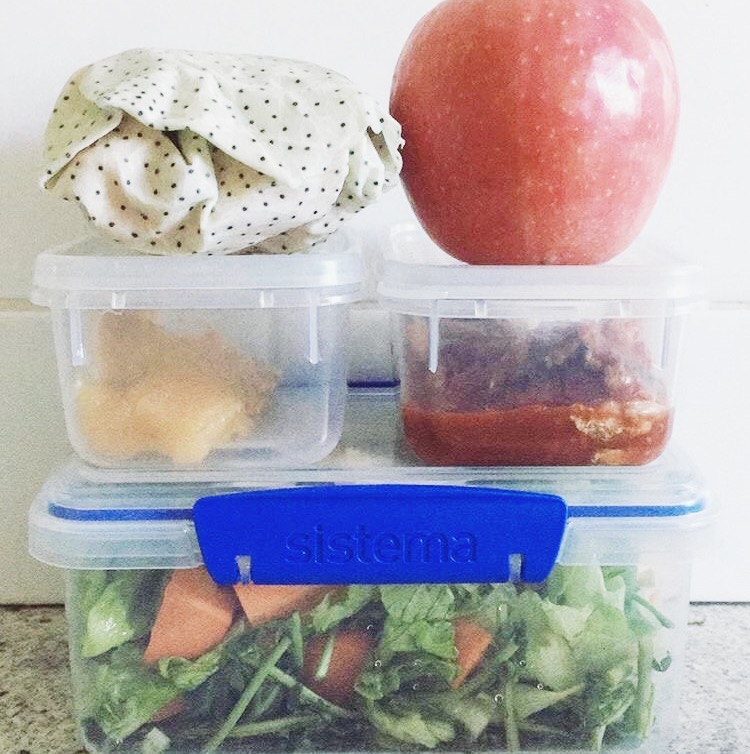 Reusable containers filled with food and an apple