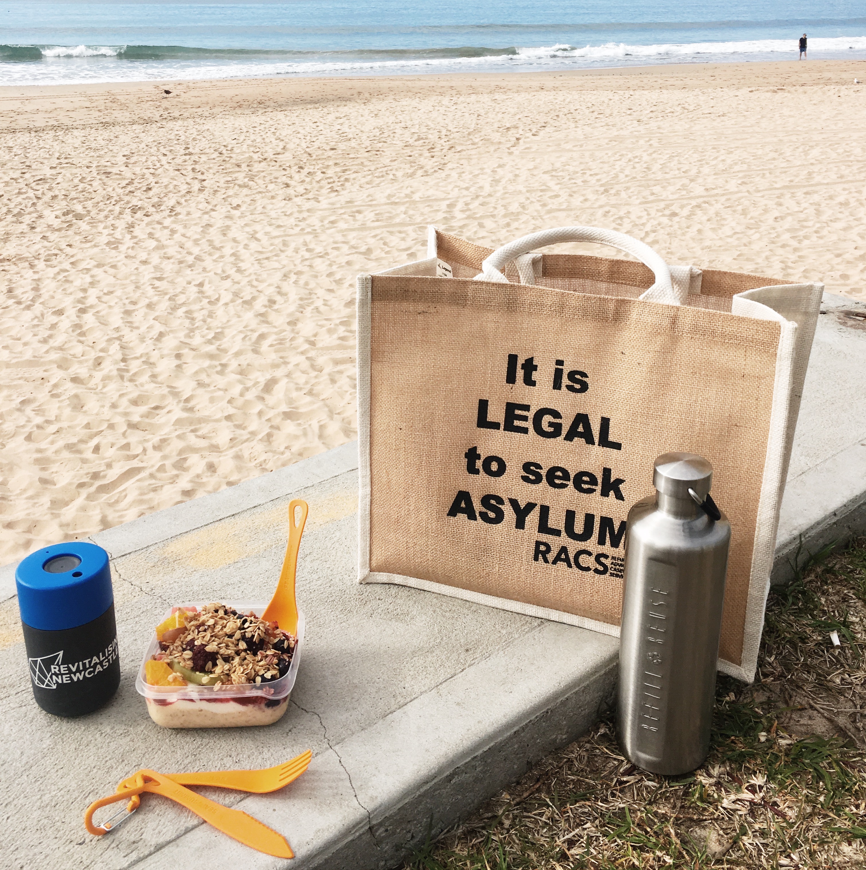 Reusable bag drink bottle and containers on the beach