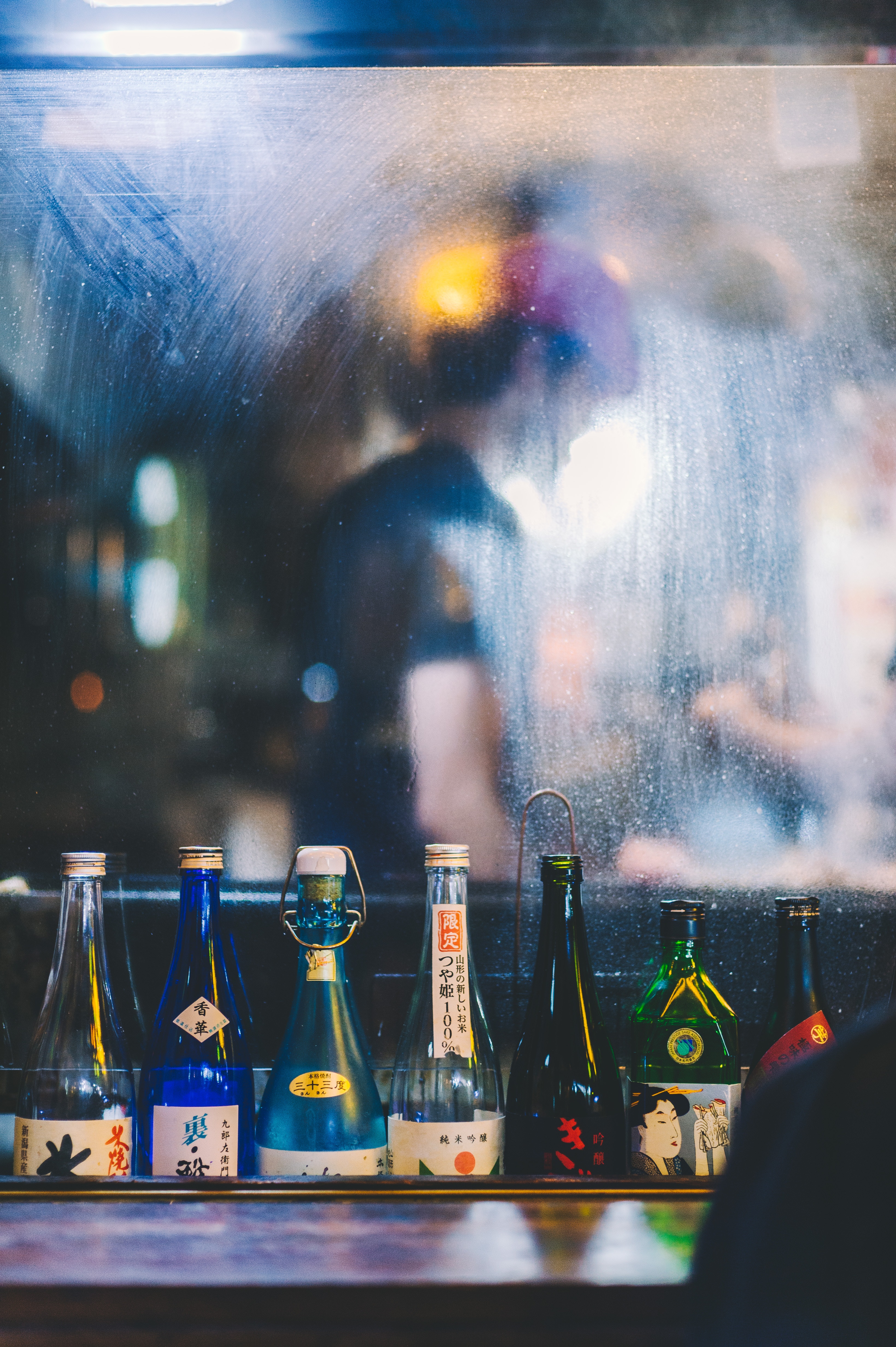 A mirror with a line of bottled alcohol in front of it