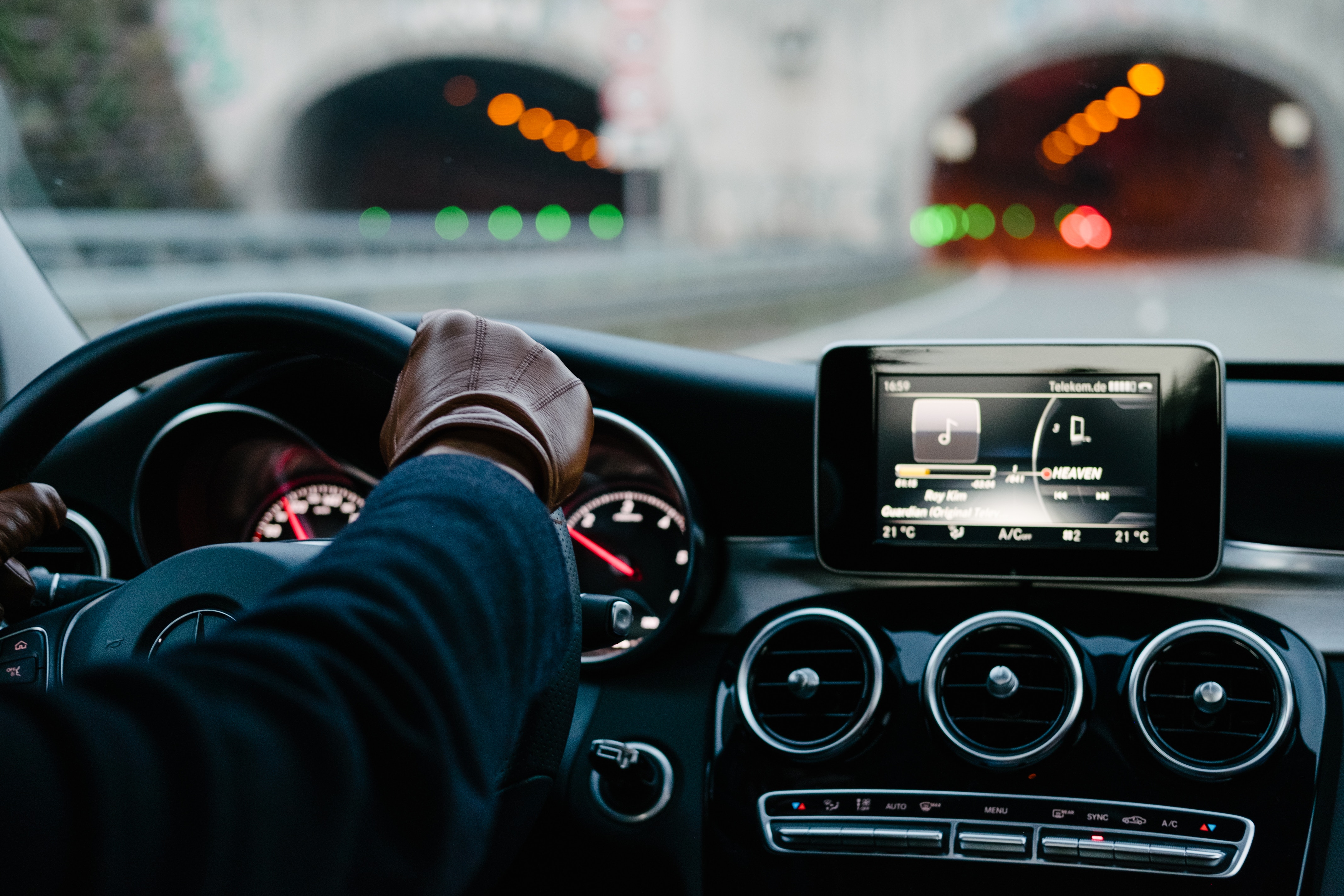 The dashboard of a car about to drive through a tunnel seen from behind the drivers seat