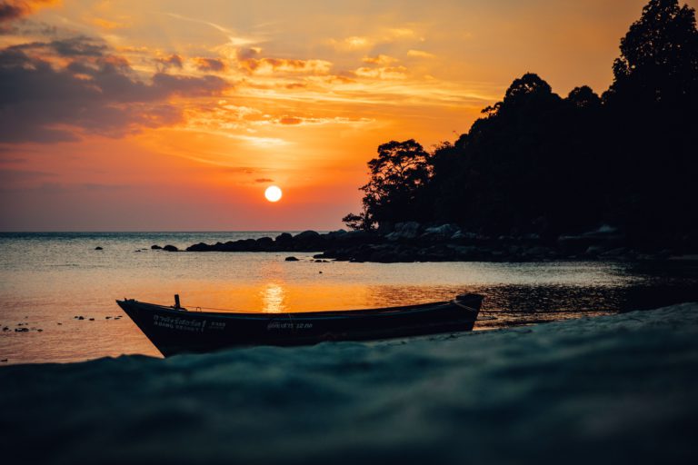 A boat onshore at sunset on Thai island of Koh Lipe