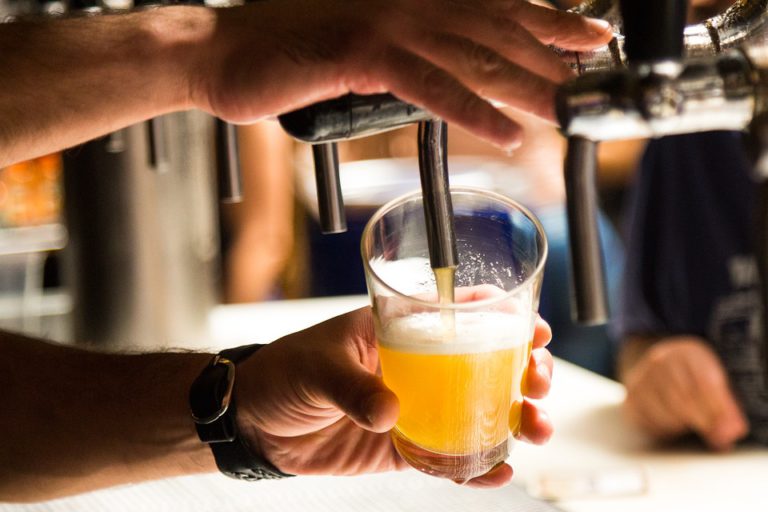 A man pouring beer from a tap in to a glass.
