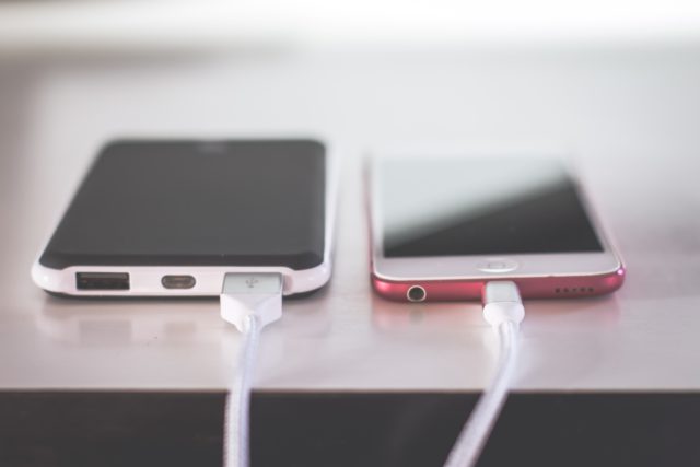 Two phones plugged in to charges travel essentials