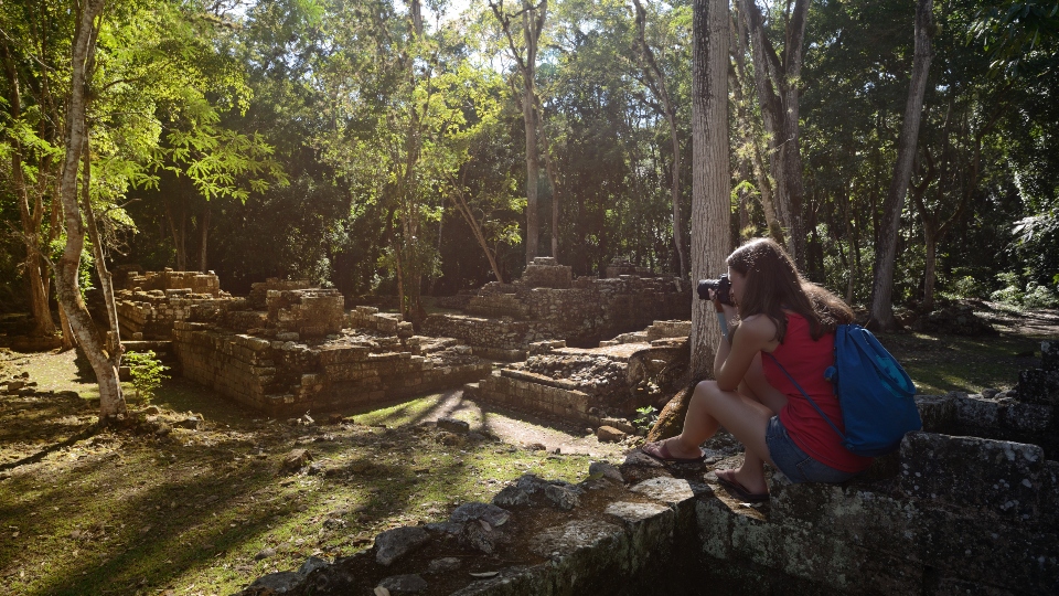 Woman photographing ancient Mayan ruins in Copan in Honduras