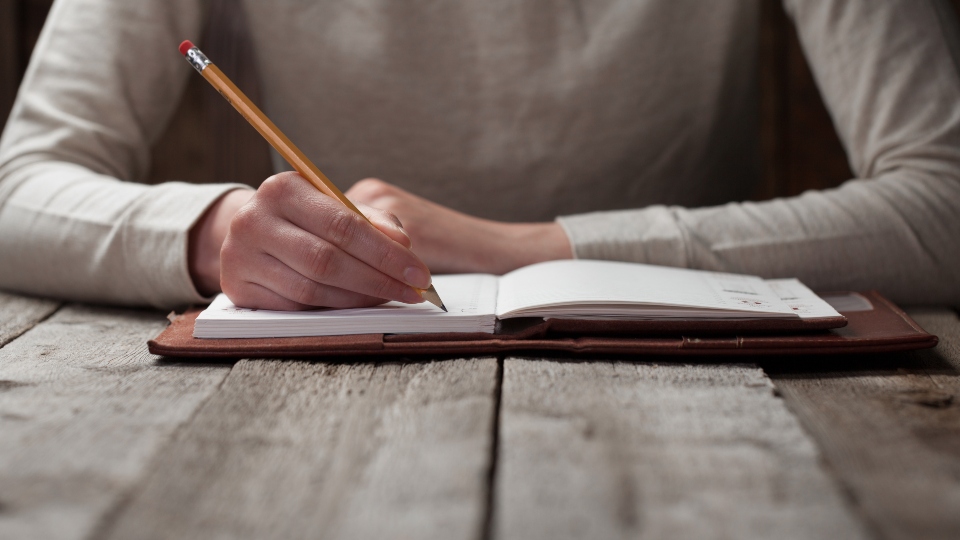 writing new experiences down in a travel diary