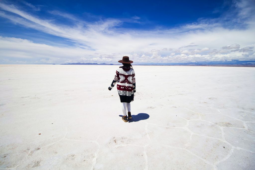 woman standing on salt flats in uyuni - bolivia - bamba travel