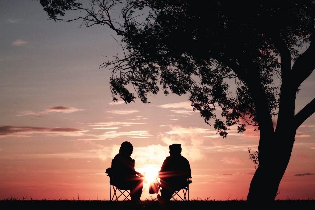 senior citizens watching sunset while hiking