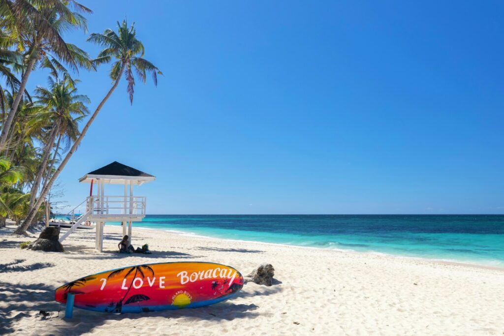 a surfboard and a lifeguard post in the whitesand of boracay philippines