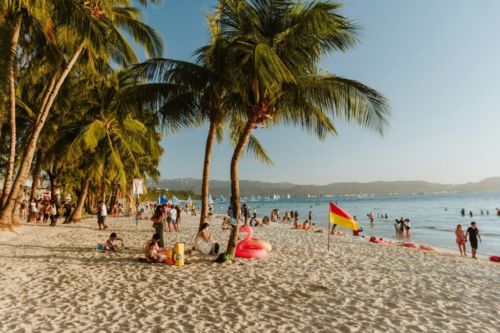 tourists on the white sand of boracay philippines