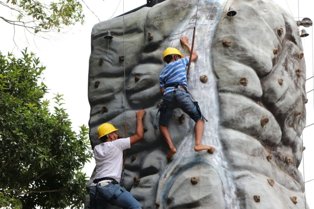 two men climbing a stonewall on volcan panama